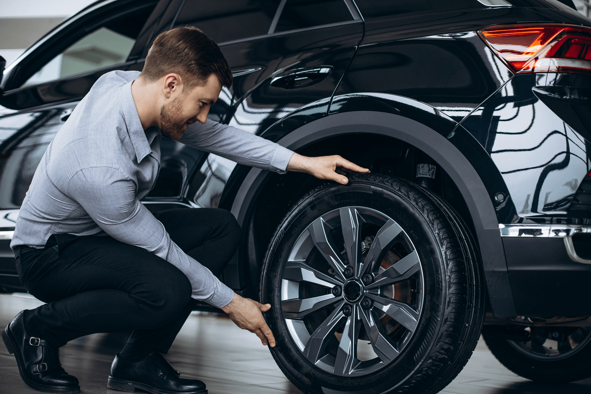 man-choosing-car-checking-tires